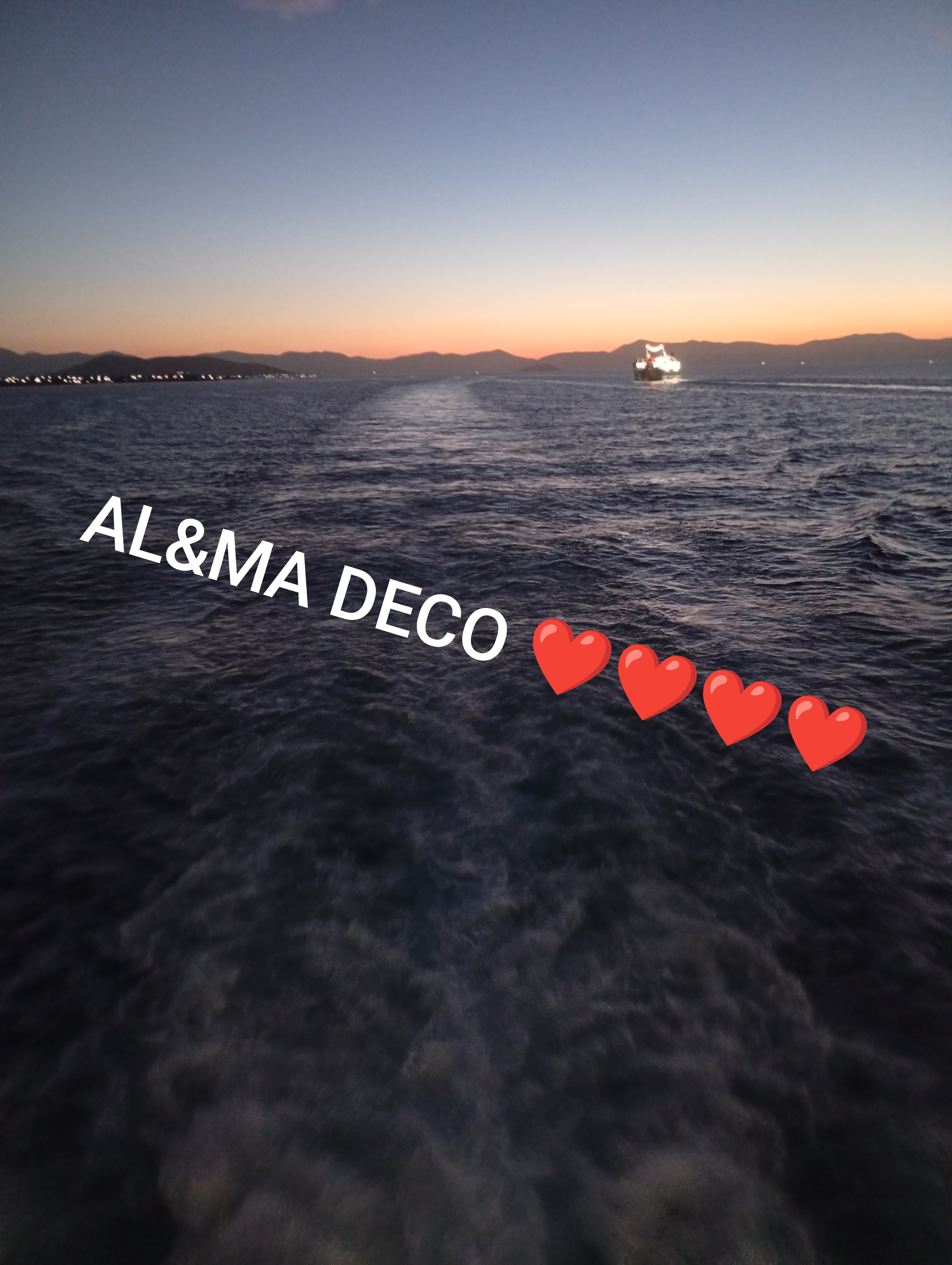 A ferry sailing on the ocean at sunset with the text 'AL&MA DECO' on the side and four overlapping red heart emojis on the foreground.